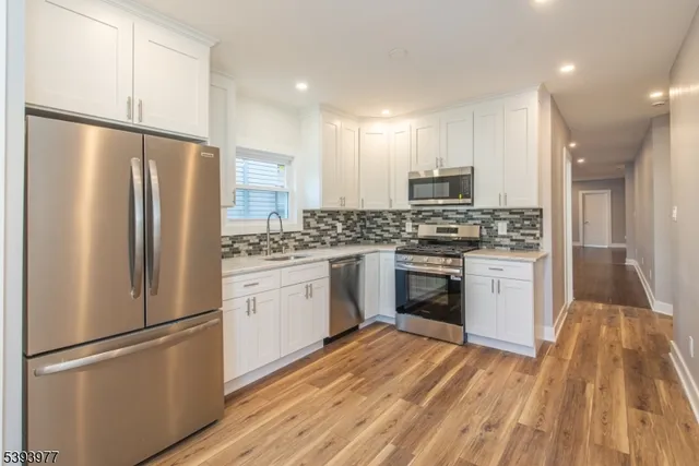 a kitchen with stainless steel appliances a refrigerator sink and microwave