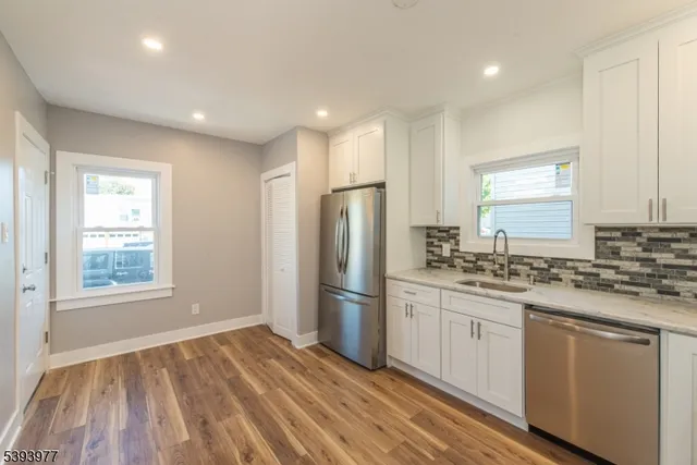 a kitchen with stainless steel appliances granite countertop a refrigerator and a stove top oven