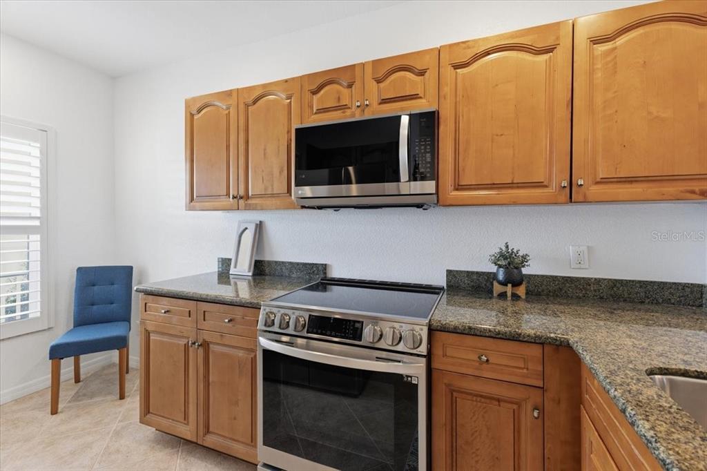 8411 Placida Road, Unit 407 Placida, FL 33946 - Photo 16 of 43 a kitchen with stainless steel appliances granite countertop a sink stove and microwave