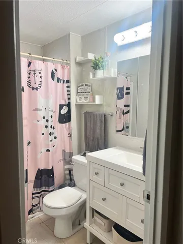 a bathroom with a toilet sink and shower curtain