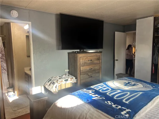 a bedroom with a bed and flat screen tv