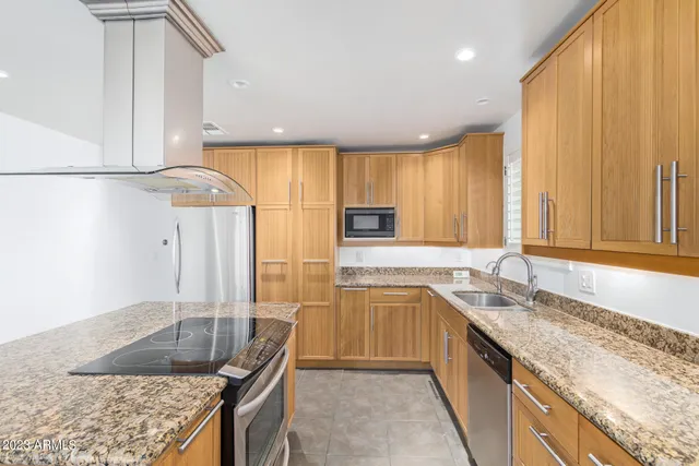 a kitchen with granite countertop a sink a counter top space and cabinets