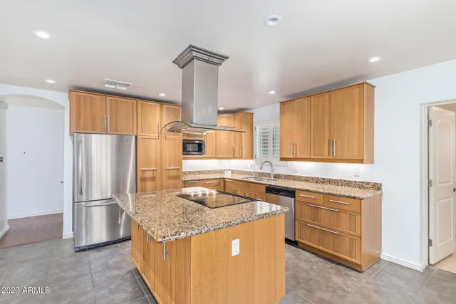 a kitchen with stainless steel appliances granite countertop a sink a stove and a refrigerator