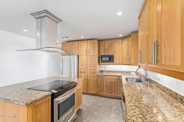 a kitchen with stainless steel appliances granite countertop a sink stove and refrigerator