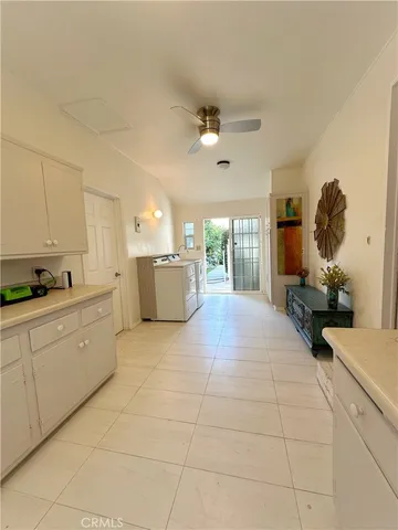 a large white kitchen with cabinets a sink a stove and a refrigerator