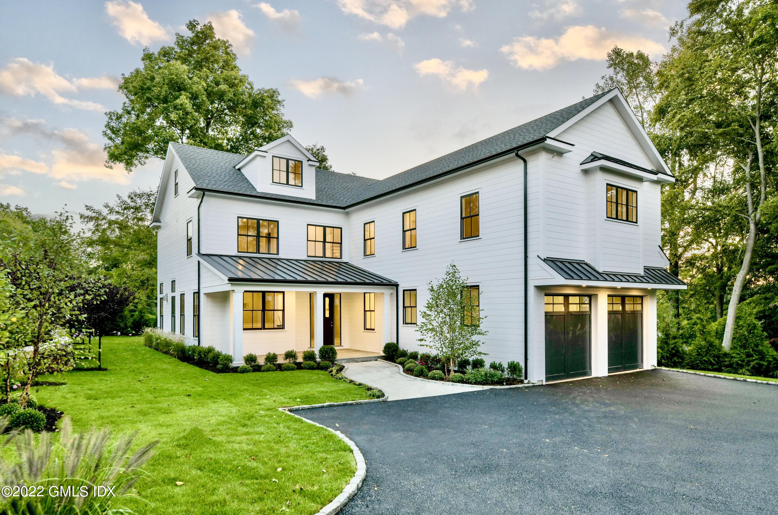 a front view of a house with a yard and trees