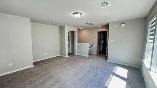 an empty room with a window and a kitchen