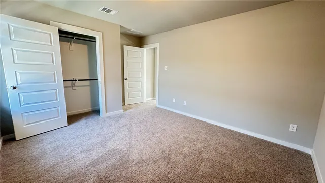 an empty room with closet and a window