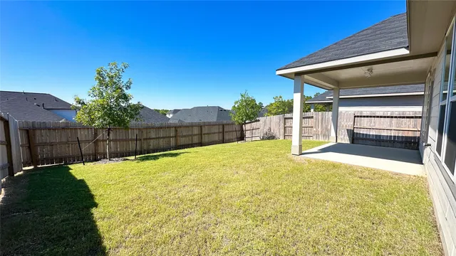 a view of backyard with wooden fence