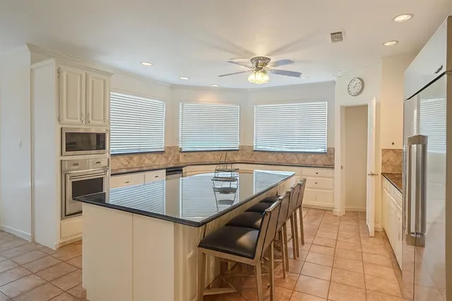 a kitchen with stainless steel appliances granite countertop a stove a refrigerator and a sink