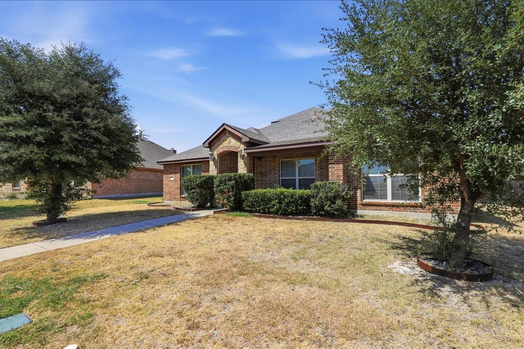 115 Blue Quail Road Red Oak, TX 75154 - Photo 34 of 35 Brick exterior with stone accents, a gabled roof, and mature trees flanking the entrance