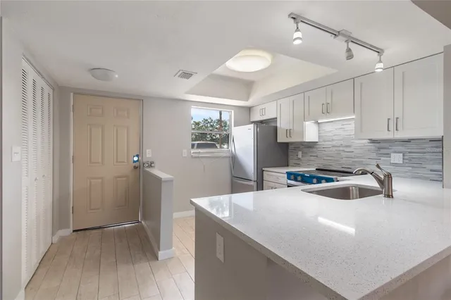 a kitchen with granite countertop a sink stove and refrigerator