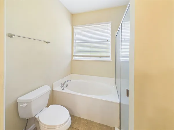 a white toilet sitting next to a bath tub