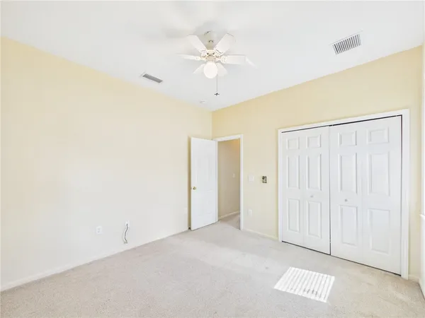 an empty room with a ceiling fan and a window