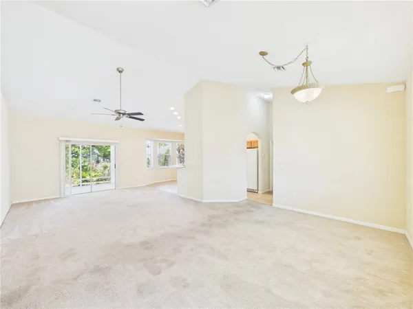 en empty room with windows and ceiling fan