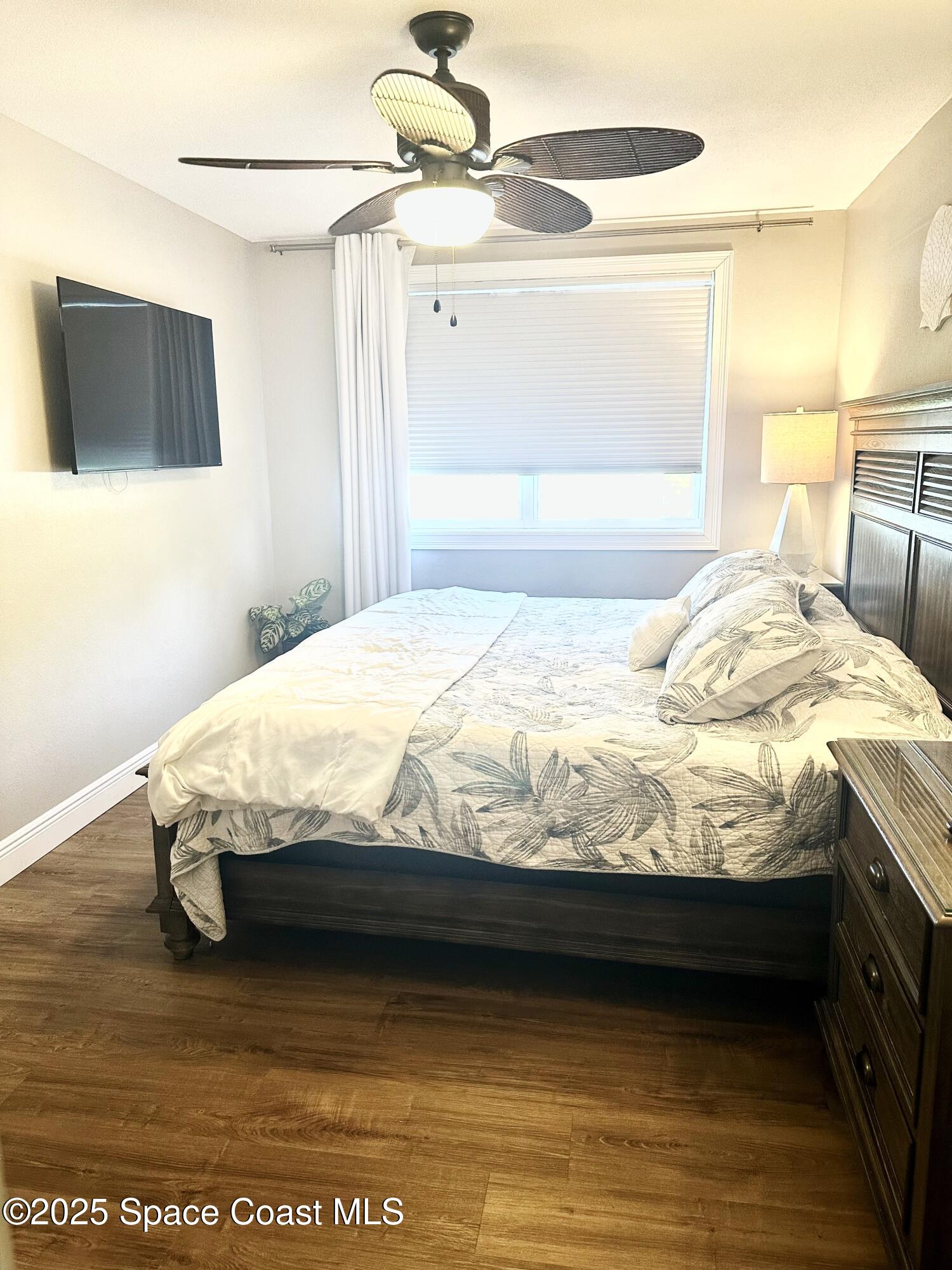 215 Buccaneer Avenue, Unit 3201 Merritt Island, FL 32952 - Photo 12 of 29 a bedroom with a bed and a flat screen tv