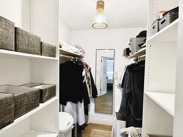 a view of walk in closet with clothes and shoes