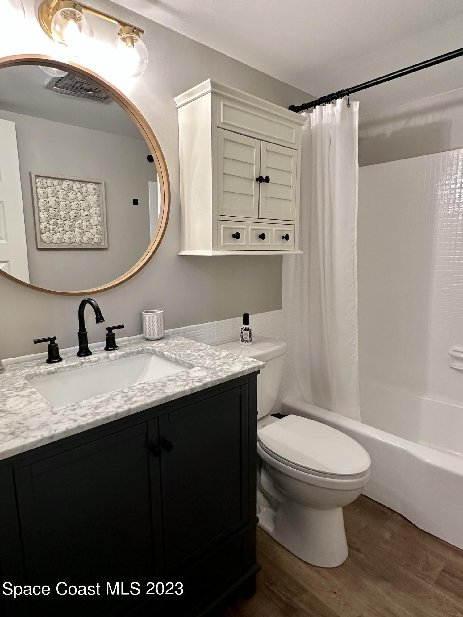 215 Buccaneer Avenue, Unit 3201 Merritt Island, FL 32952 - Photo 15 of 29 a bathroom with a granite countertop sink toilet and shower