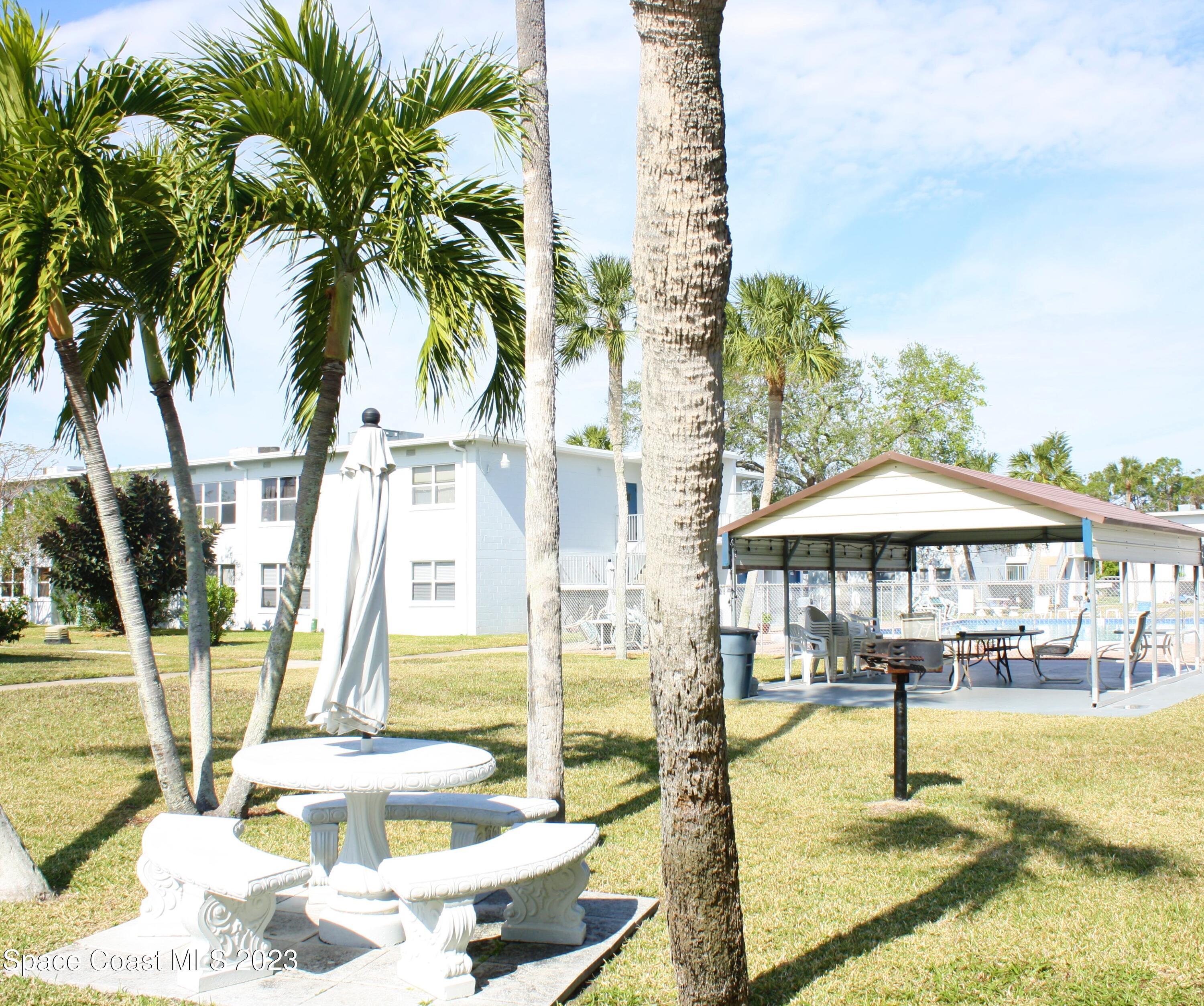 215 Buccaneer Avenue, Unit 3201 Merritt Island, FL 32952 - Photo 23 of 29 a swimming pool with outdoor seating and yard