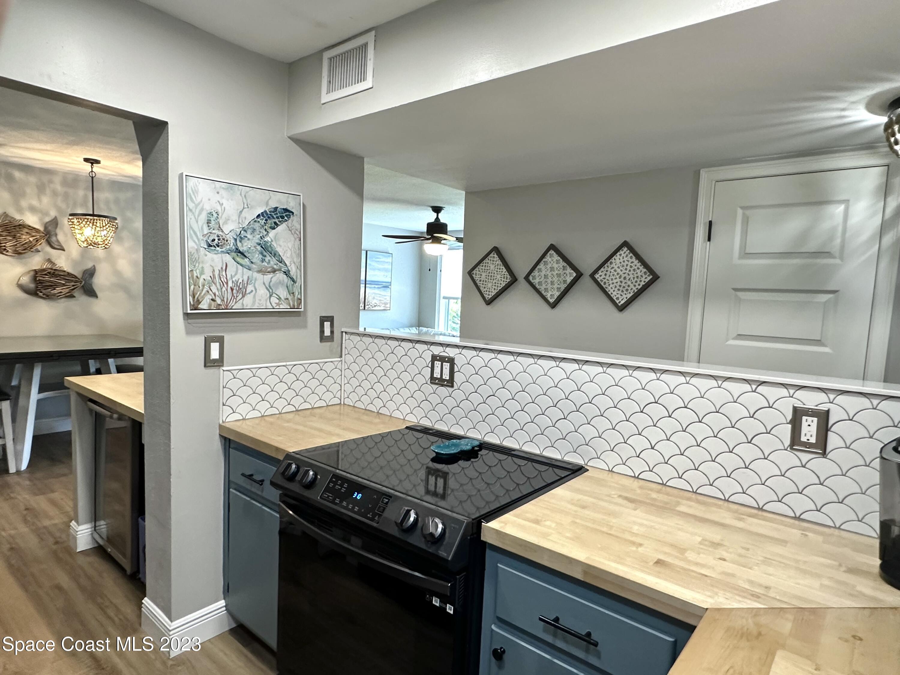 215 Buccaneer Avenue, Unit 3201 Merritt Island, FL 32952 - Photo 7 of 29 a kitchen with a stove and a refrigerator