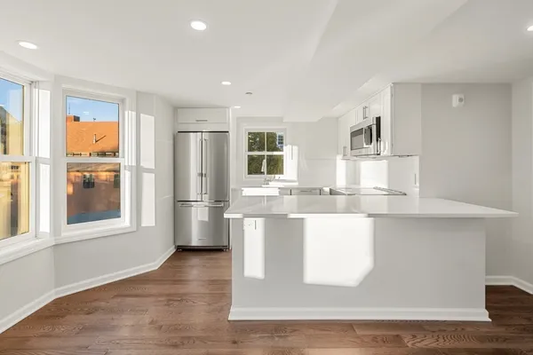 a view of a kitchen with stainless steel appliances granite countertop a refrigerator and cabinets