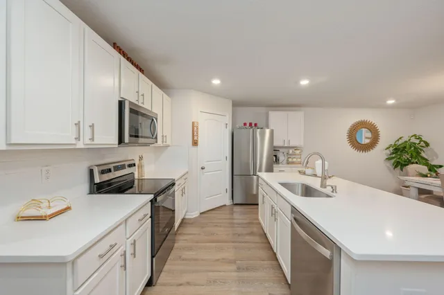 a kitchen with stainless steel appliances a sink stove and cabinets