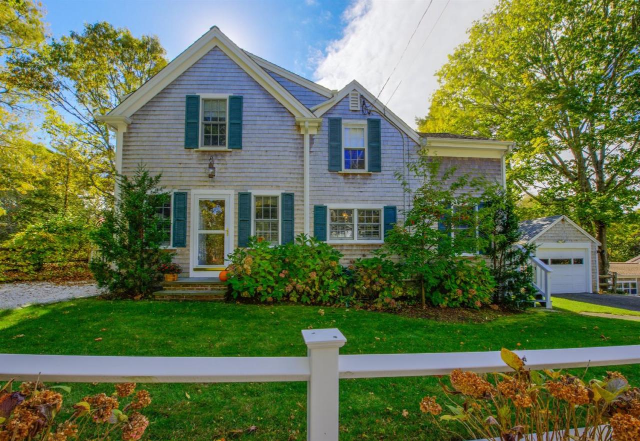 a front view of a house with a yard and trees