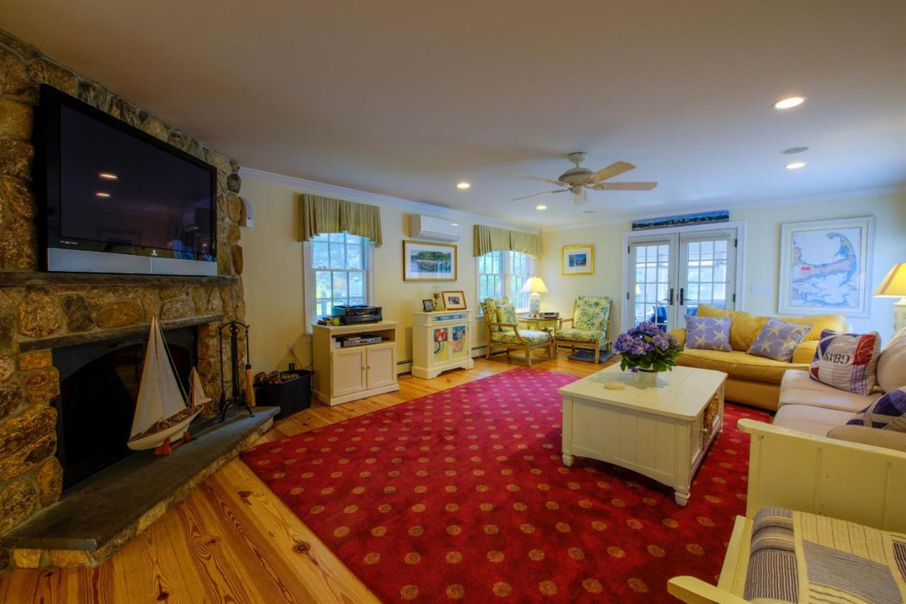 65 Shell Lane Cotuit, MA 02635 - Photo 7 of 32 a living room with furniture a flat screen tv and a fireplace