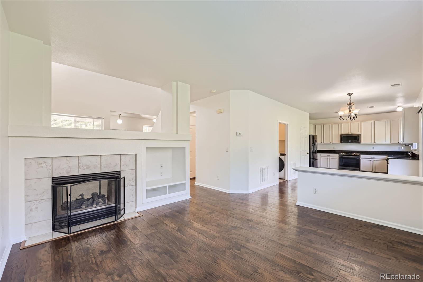 10562 Tracewood Circle Highlands Ranch, CO 80130 - Photo 12 of 28 a view of a kitchen with a sink a fireplace and wooden floor