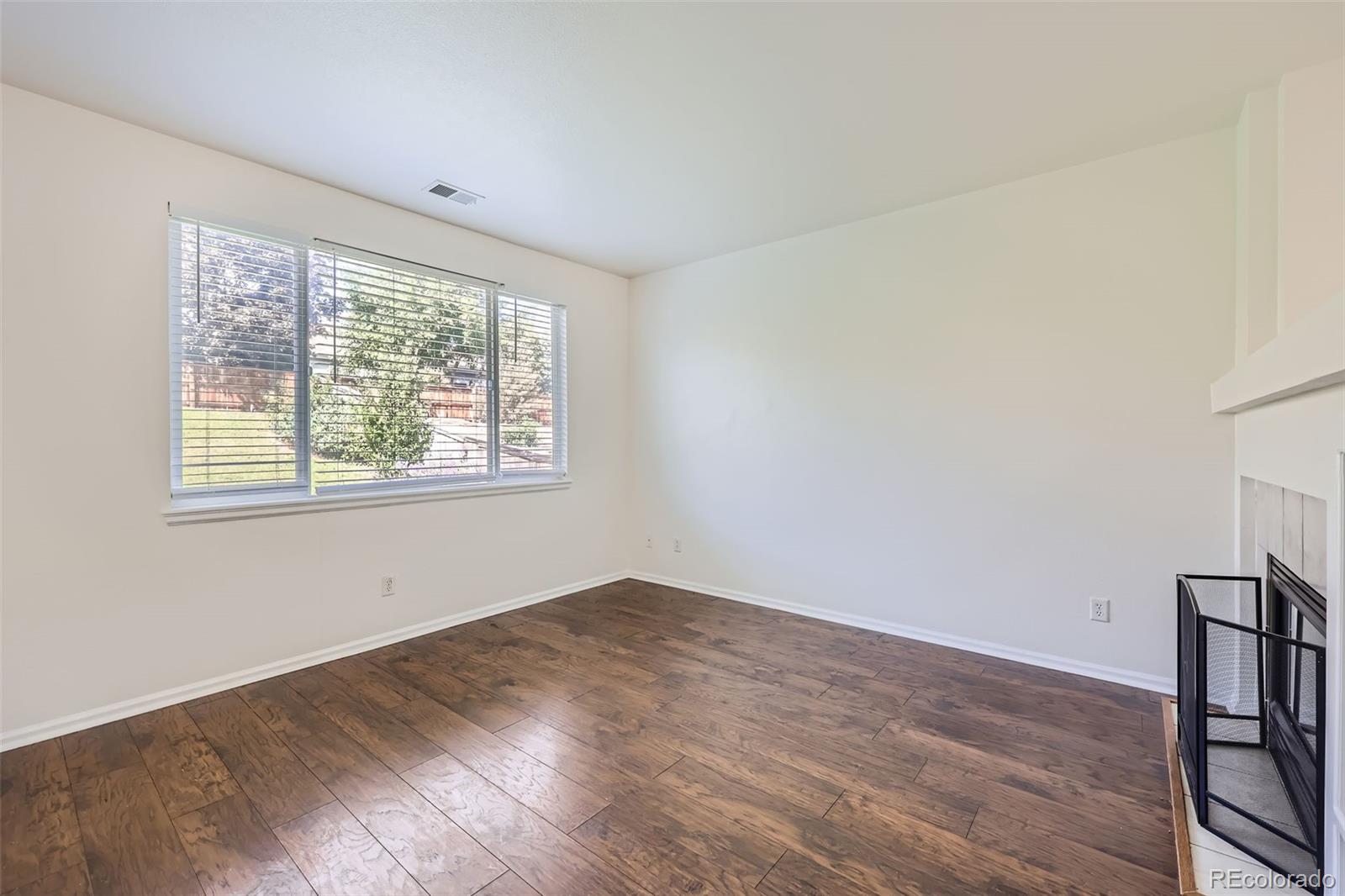 10562 Tracewood Circle Highlands Ranch, CO 80130 - Photo 13 of 28 a view of an empty room with wooden floor and a window