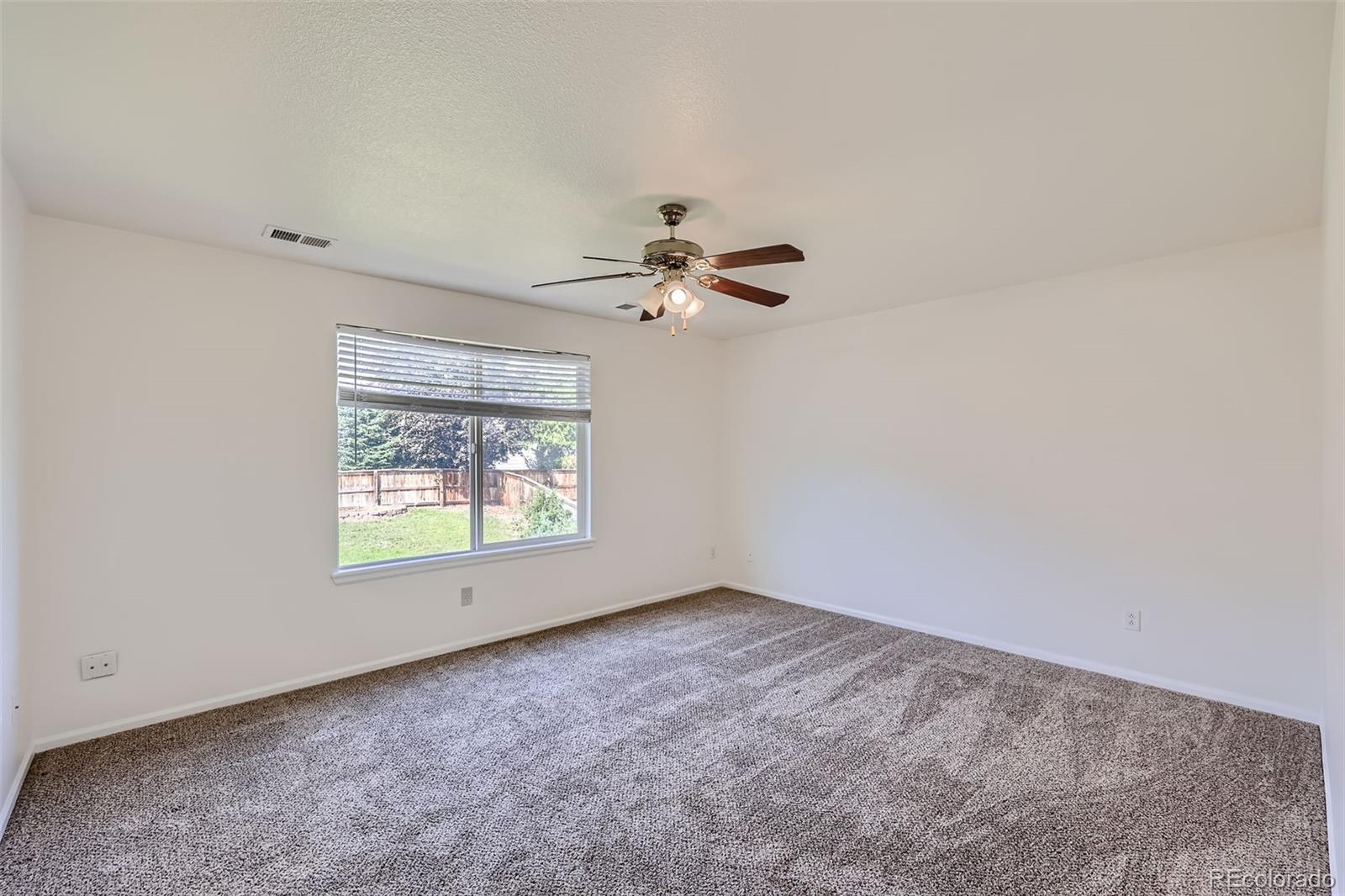 10562 Tracewood Circle Highlands Ranch, CO 80130 - Photo 15 of 28 an empty room with a window and a ceiling fan