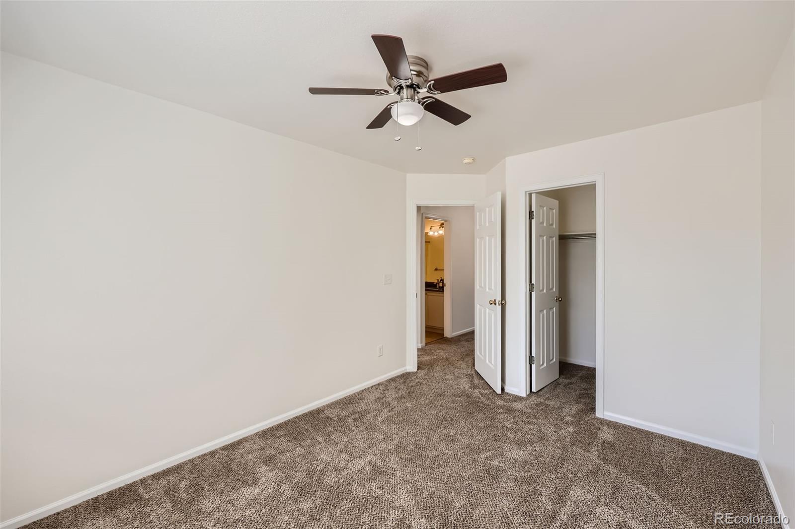 10562 Tracewood Circle Highlands Ranch, CO 80130 - Photo 20 of 28 a view of a livingroom with a ceiling fan and refrigerator