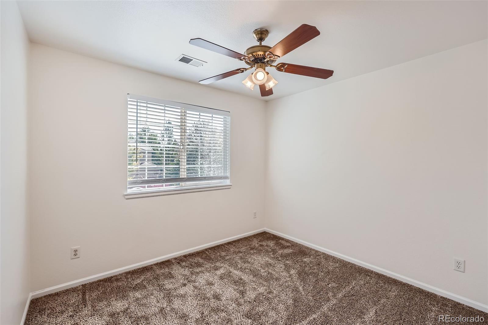 10562 Tracewood Circle Highlands Ranch, CO 80130 - Photo 22 of 28 an empty room with window and ceiling fan