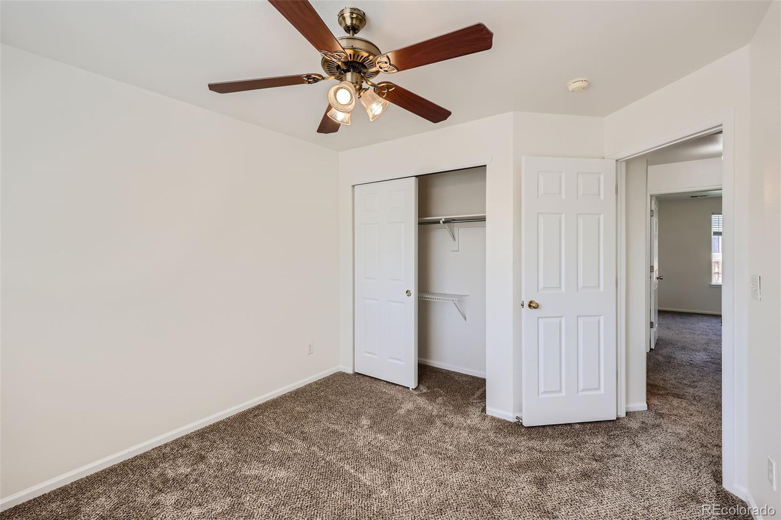 10562 Tracewood Circle Highlands Ranch, CO 80130 - Photo 23 of 28 an empty room with a ceiling fan