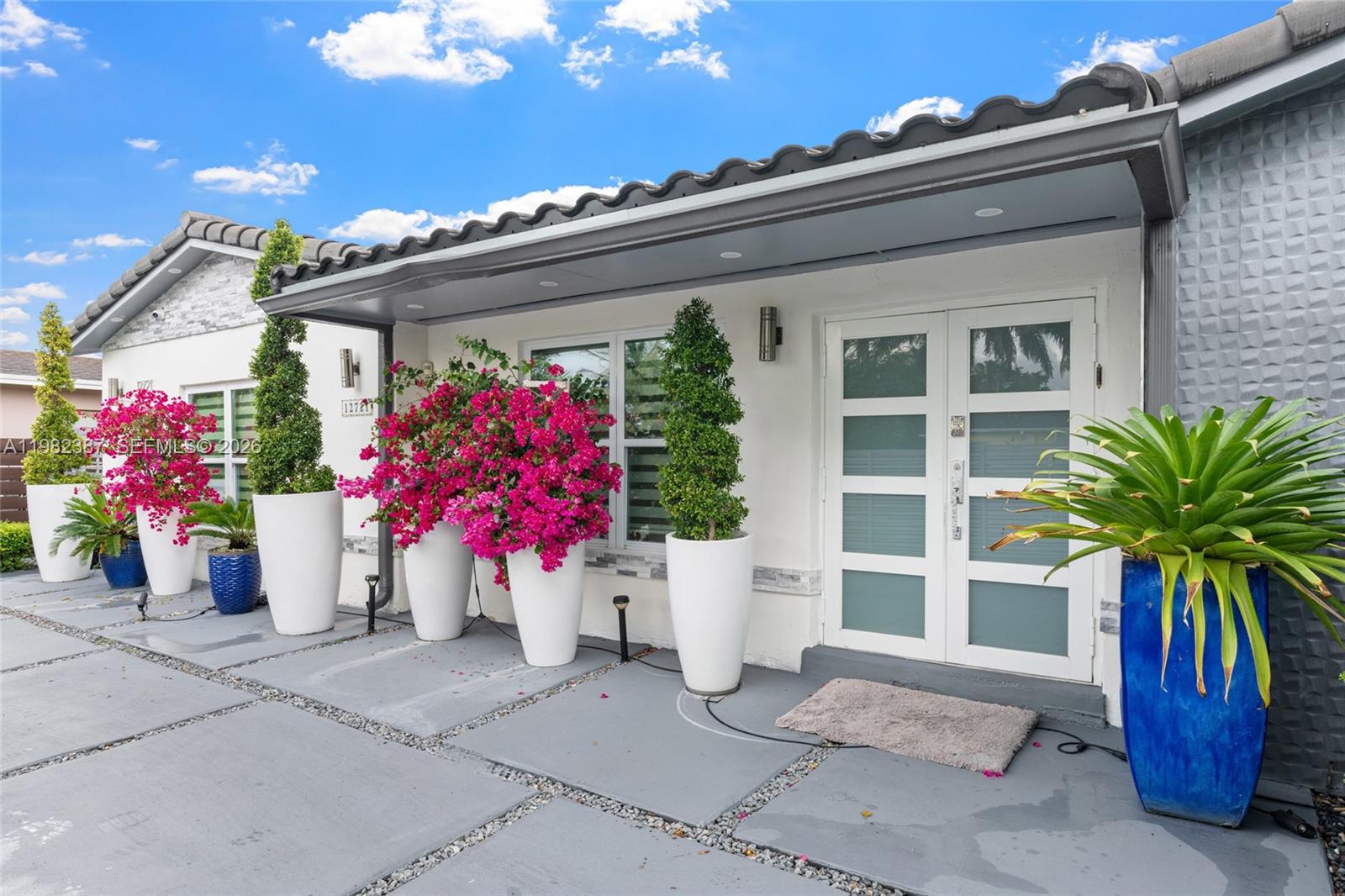12721 Southwest 47th Street Miami, FL 33175 - Photo 4 of 47 a front view of a house with a potted plant and a garage