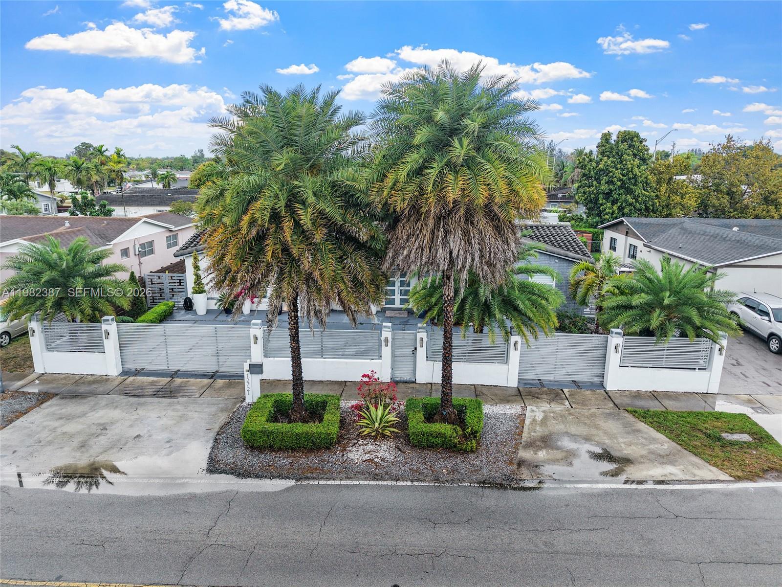 12721 Southwest 47th Street Miami, FL 33175 - Photo 42 of 47 a palm tree sitting in front of a house with a garden