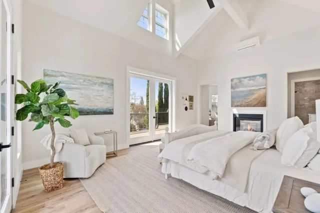 a living room with furniture large window and potted plants