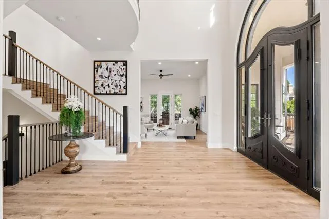 a view of a white house with large windows and a small yard
