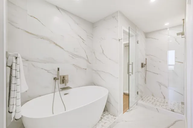 a white bath tub sitting in a bathroom and shower