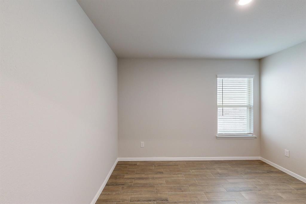 408 Wydown Drive Princeton, TX 75407 - Photo 14 of 40 a view of an empty room with wooden floor and a window