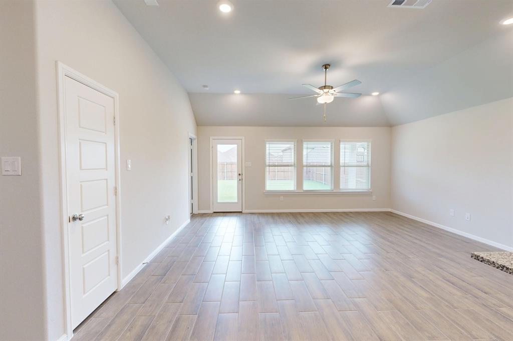 408 Wydown Drive Princeton, TX 75407 - Photo 2 of 40 an empty room with wooden floor ceiling fan and windows