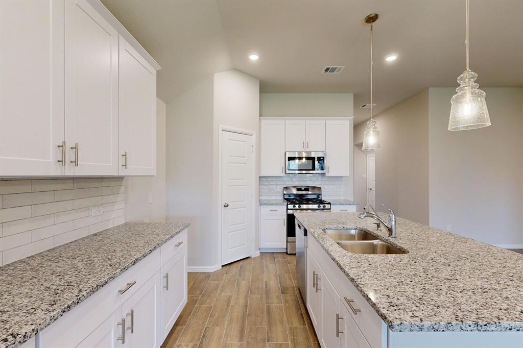 408 Wydown Drive Princeton, TX 75407 - Photo 3 of 40 a kitchen with granite countertop a sink stove and refrigerator