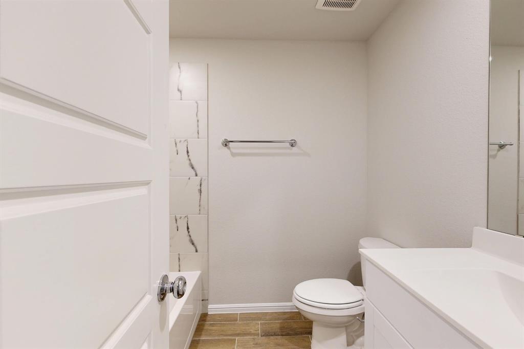 408 Wydown Drive Princeton, TX 75407 - Photo 10 of 40 a bathroom with a granite countertop toilet and a sink
