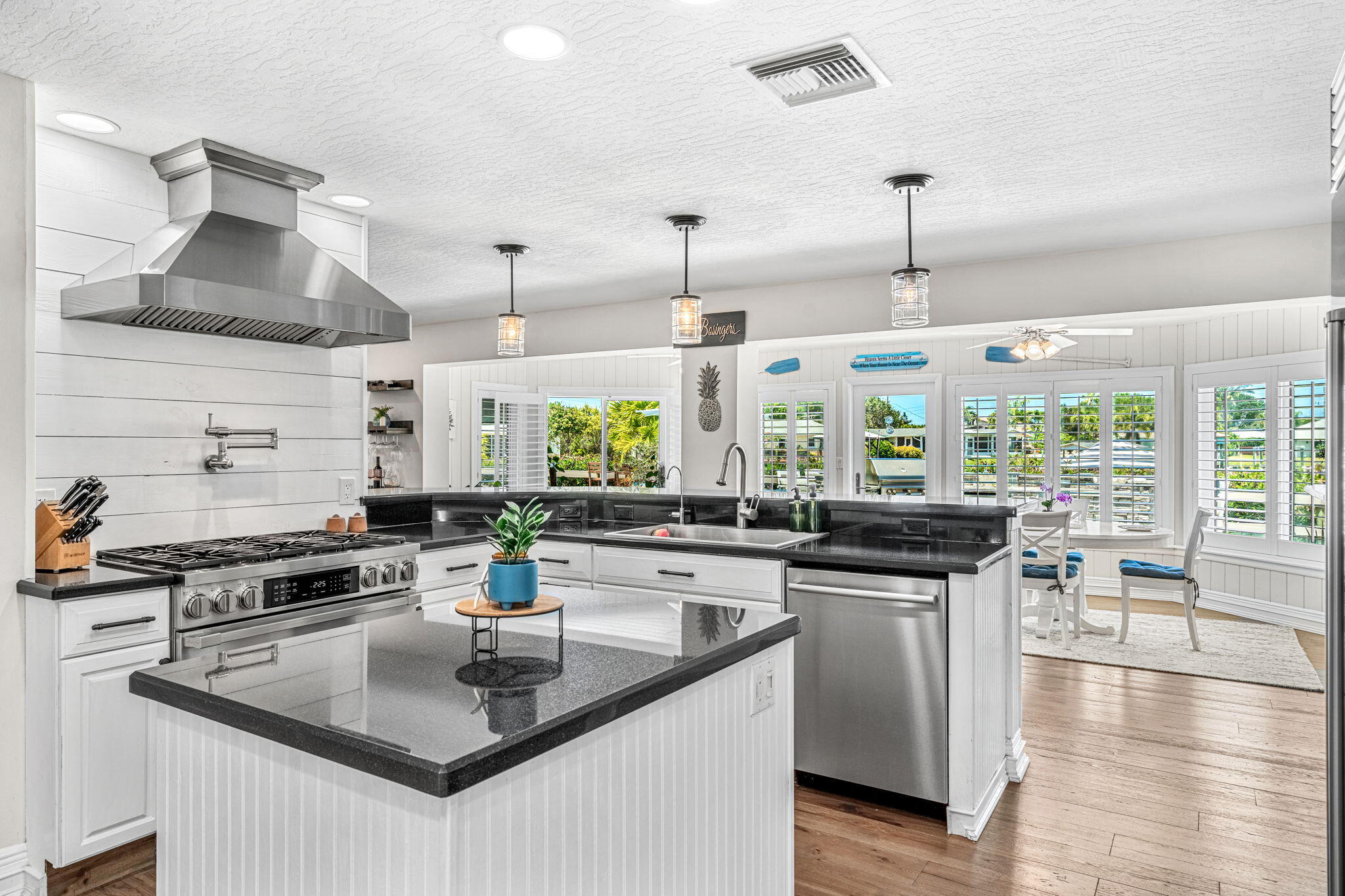 452 Sandy Key Melbourne Beach, FL 32951 - Photo 44 of 140 a kitchen with stainless steel appliances granite countertop a sink a stove and a wooden floors