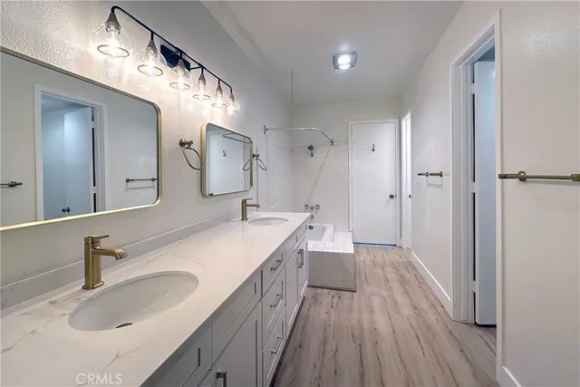 a bathroom with a sink double vanity granite tub and shower