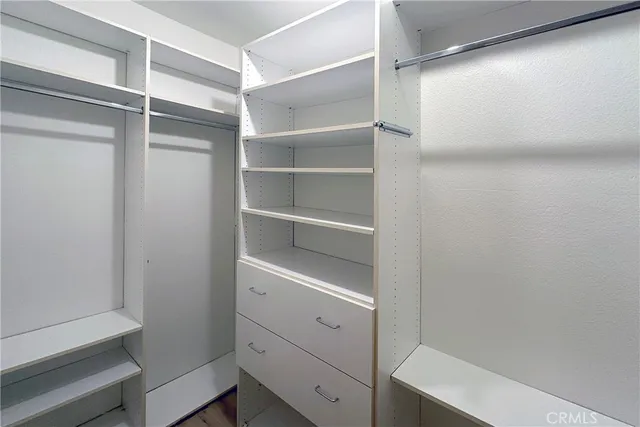a view of walk in closet with empty racks