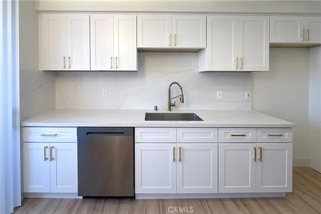 a kitchen with white cabinets and a hard wood floors