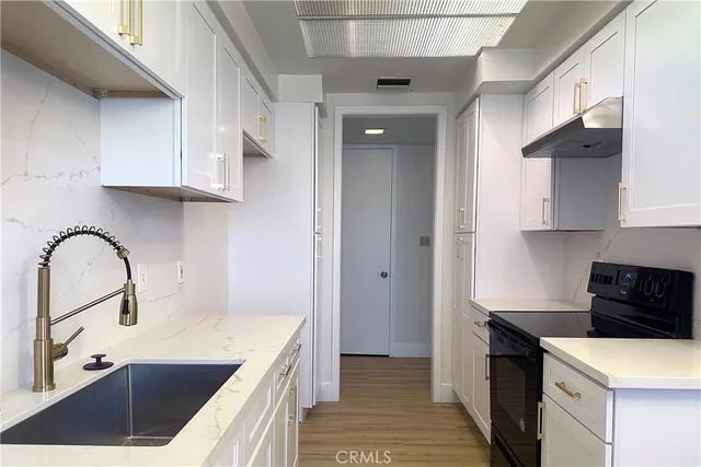 a kitchen with a sink a stove and cabinets