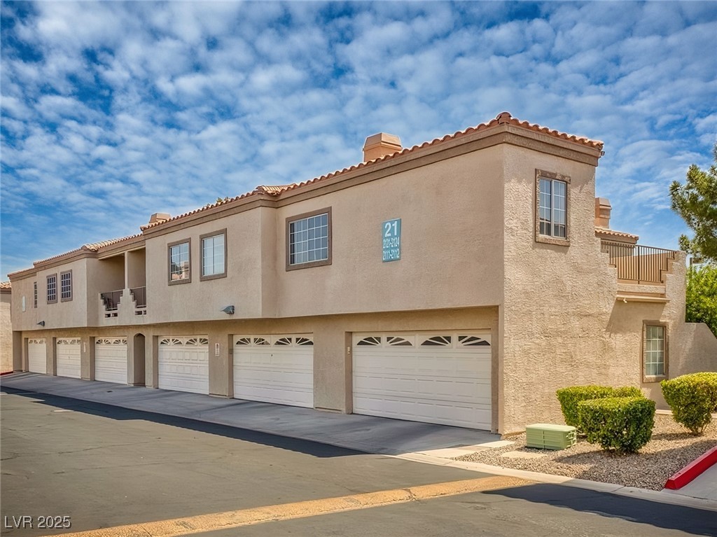 1851 Hillpointe Road, Unit 2124 Henderson, NV 89074 - Photo 1 of 24 View of front of home featuring driveway, stucco siding, a tiled roof, and an attached garage