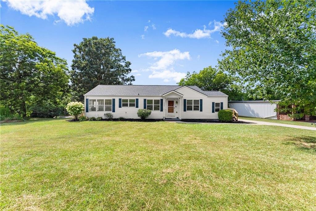 6455 Main Street Lula, GA 30554 - Photo 2 of 43 a front view of a house with a garden